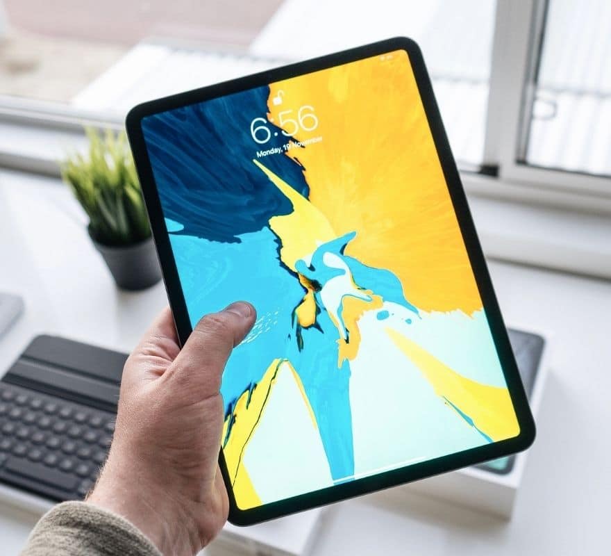 Man holding an iPad with a colourful lock screen