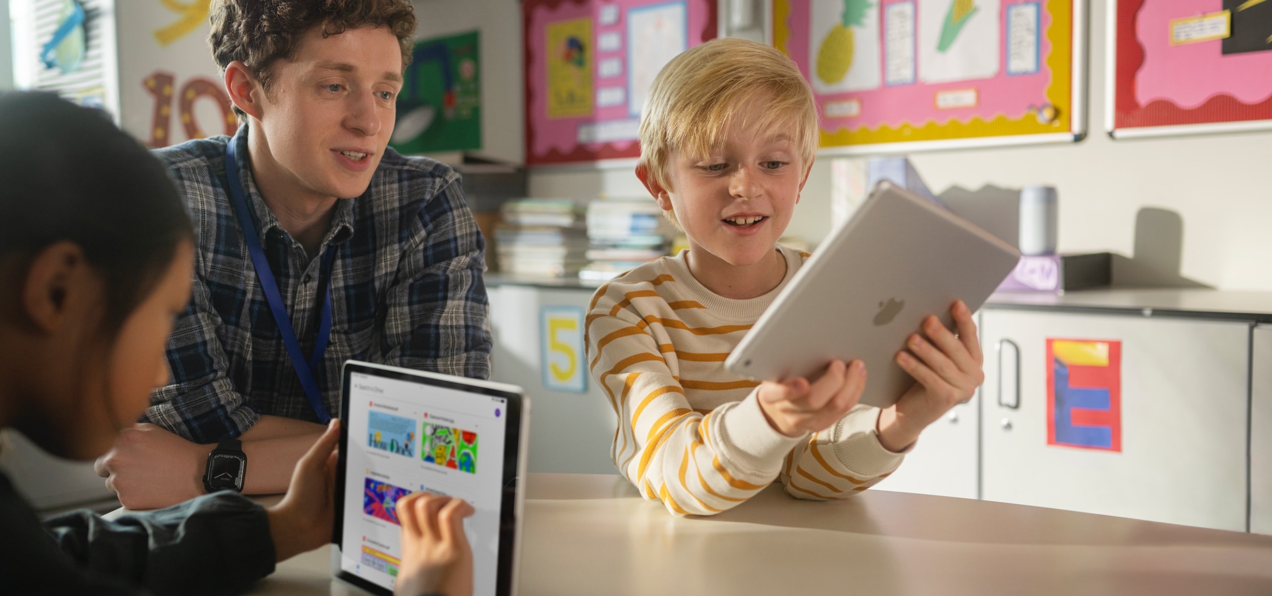 Teacher supporting students with iPad